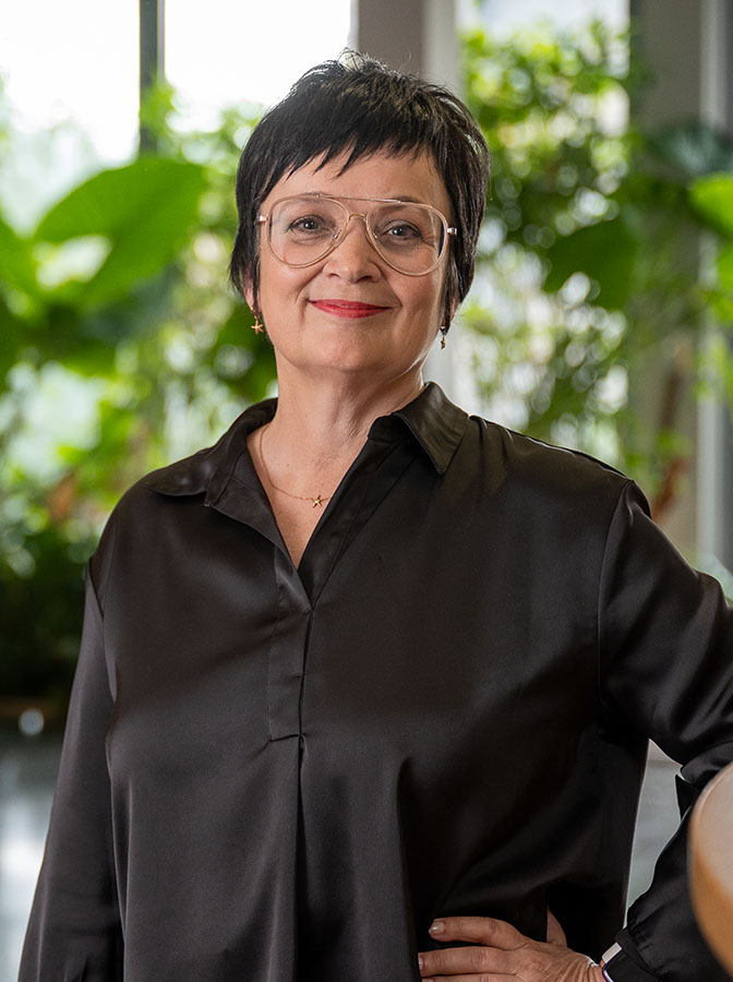 Portraitfoto einer Frau mit Brille und schwarzer Bluse