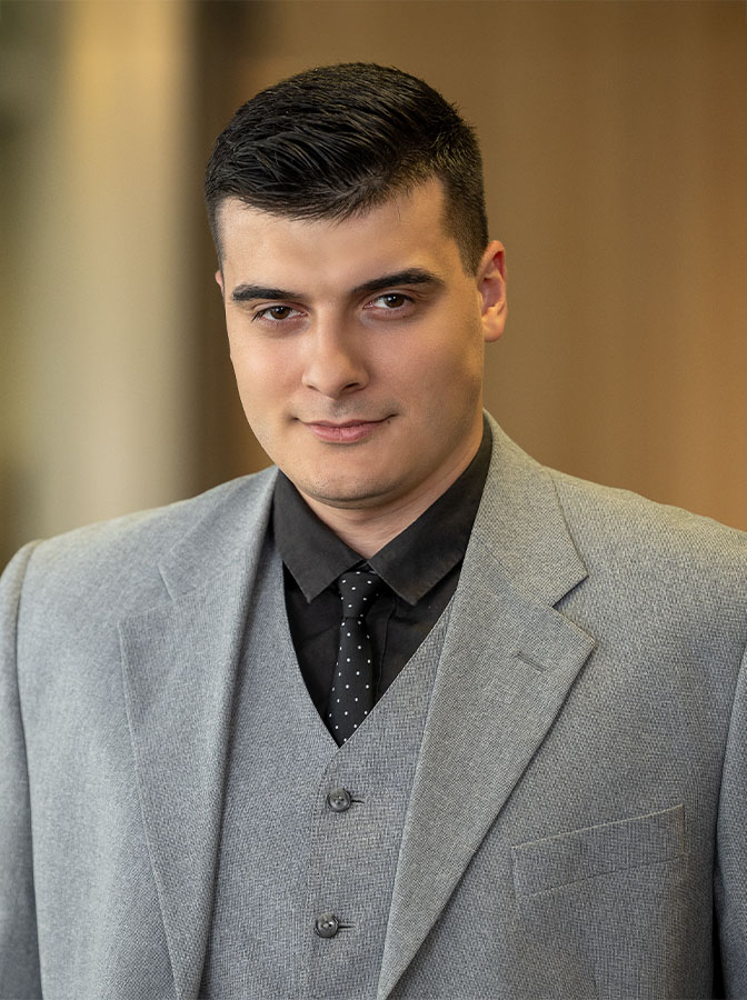 Portraitfoto eines Mannes mit grauem Business-Dreiteiler