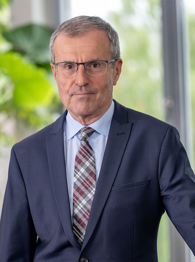Portraitfoto eines Mannes mit Brille und blauem Anzug