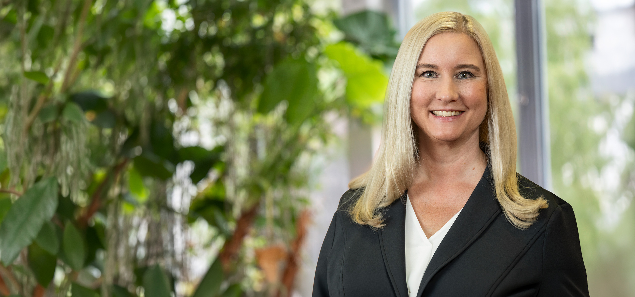 Foto einer Frau mit heller Bluse und dunklem Blazer