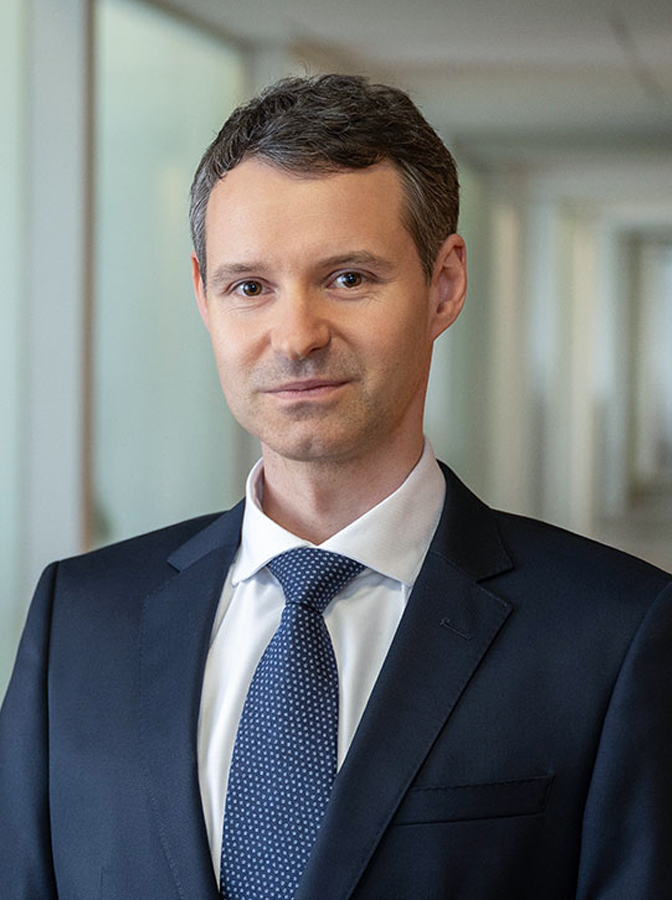 Portraitfoto eines Herren mit dunkelblauem Anzug und Krawatte