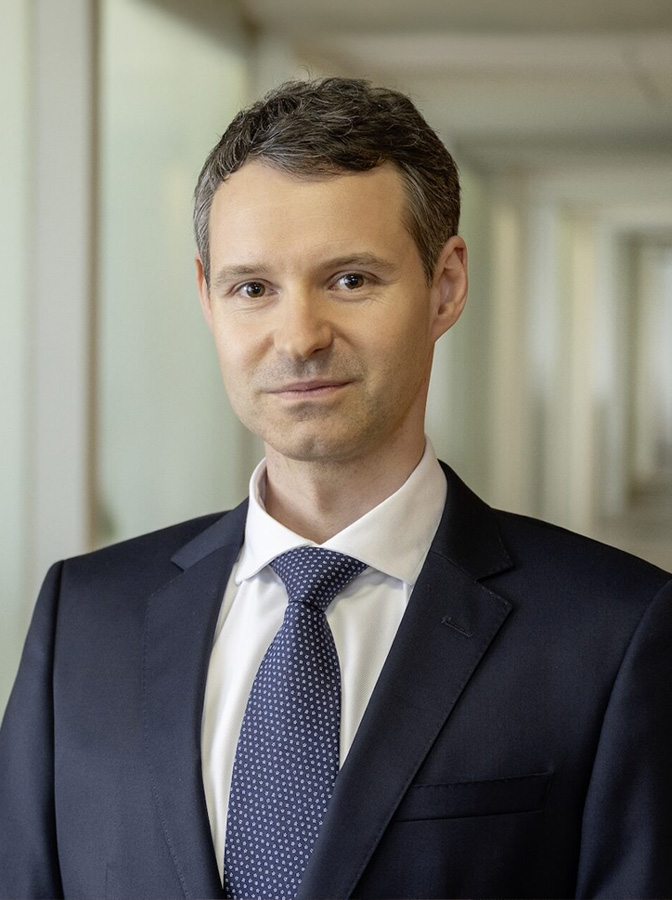 Portraitfoto eines Herren mit dunkelblauem Anzug und Krawatte