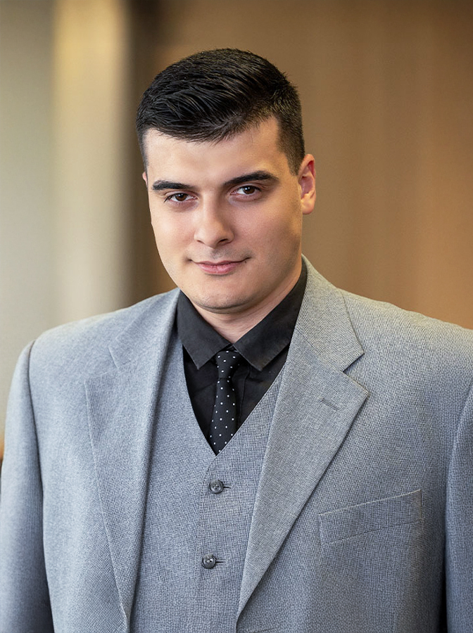 Portraitfoto eines Mannes mit grauem Business-Dreiteiler