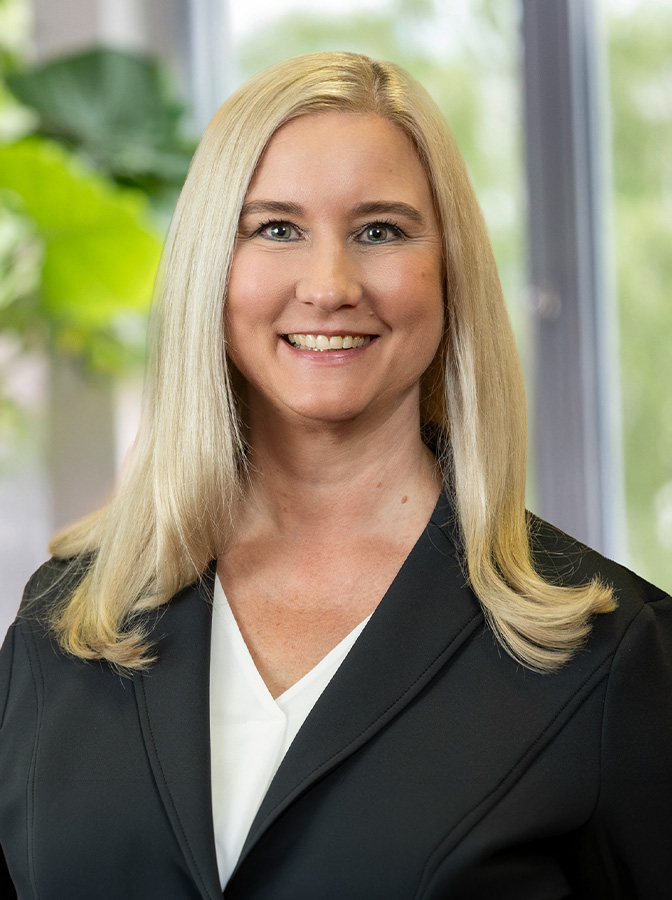 Portraitfoto einer Frau mit heller Bluse und dunklem Blazer