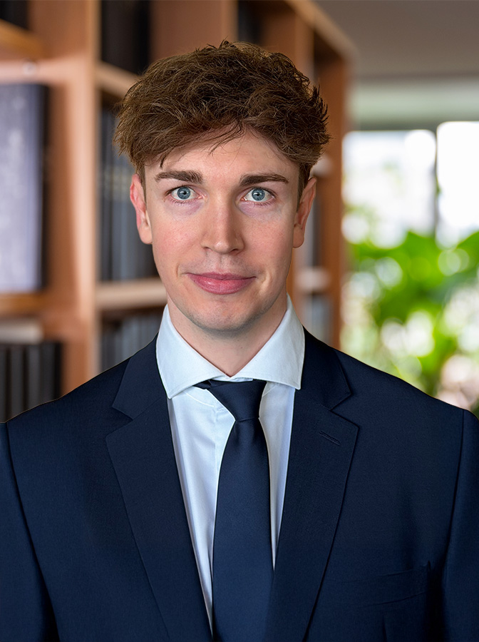 Portraitfoto eines Herren mit schwarzem Anzug und schwarzer Krawatte