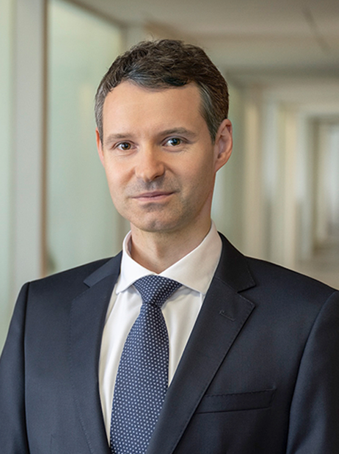 Portraitfoto eines Herren mit dunkelblauem Anzug und Krawatte
